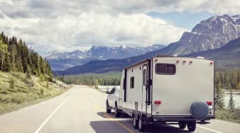 rv, trees, mountain and road