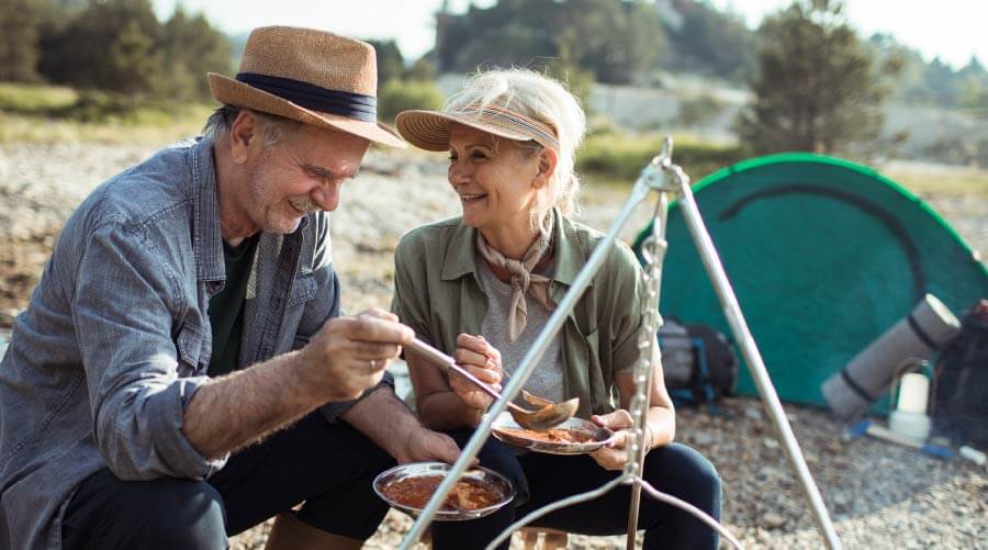 retired couple at campfire daytime eating