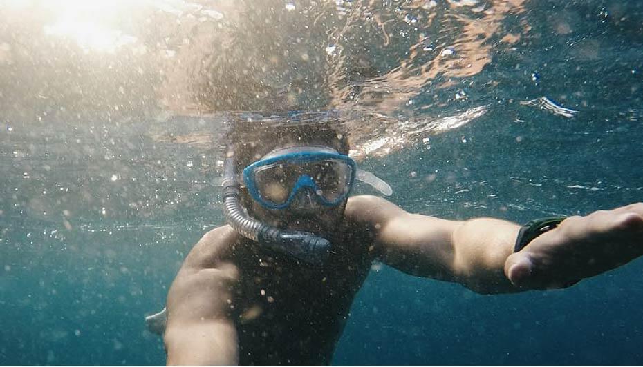 man diving under ocean water